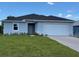 Charming single-story home with a manicured lawn and attached two-car garage at 198 Arch Dr, Rotonda West, FL 33947
