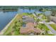Waterfront property featuring a screened pool, lush landscaping and direct access to the lake at 2202 Peterborough Rd, Punta Gorda, FL 33983