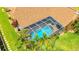 Overhead shot of a screened-in pool and outdoor living space surrounded by lush green landscaping and palm trees at 2202 Peterborough Rd, Punta Gorda, FL 33983