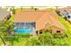 Aerial view of a home with a screened-in pool, manicured lawn, and mature palm trees at 2202 Peterborough Rd, Punta Gorda, FL 33983