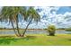 Beautiful backyard featuring a well-manicured lawn, lush landscaping, and serene water views at 2202 Peterborough Rd, Punta Gorda, FL 33983