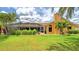 Expansive backyard featuring a screened-in porch, lush lawn, and tropical landscaping, perfect for outdoor living at 2202 Peterborough Rd, Punta Gorda, FL 33983