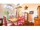 Bright dining room featuring a decorative light fixture, red chairs, and a large window at 2202 Peterborough Rd, Punta Gorda, FL 33983