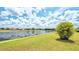 Lush backyard showcasing serene lake views with clear blue sky and manicured landscaping at 2202 Peterborough Rd, Punta Gorda, FL 33983