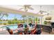 Covered patio with ceiling fans overlooks pool with palm trees and lush landscaping at 2202 Peterborough Rd, Punta Gorda, FL 33983