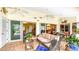 Covered patio featuring comfortable seating, ceiling fans, and lush tropical landscaping at 2202 Peterborough Rd, Punta Gorda, FL 33983