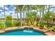 Relaxing in-ground pool surrounded by palm trees, lush landscaping and a beautiful screened enclosure at 2202 Peterborough Rd, Punta Gorda, FL 33983