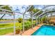 The screen-enclosed in-ground pool offers an ideal outdoor oasis near the lake, enhanced by beautiful landscaping at 2202 Peterborough Rd, Punta Gorda, FL 33983