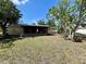 Expansive backyard with lush grass and mature trees presents an inviting outdoor space at 2314 Lee Ter, Port Charlotte, FL 33952