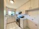 Bright kitchen featuring white cabinets, stainless steel appliances, and tiled countertops at 2314 Lee Ter, Port Charlotte, FL 33952