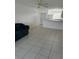 Open living area with tiled floors connecting to the kitchen and entrance door at 25050 Sandhill Blvd # B3, Punta Gorda, FL 33983