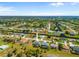 Expansive aerial view of a residential neighborhood with lush landscaping and nearby water features at 265 White Marsh Ln, Rotonda West, FL 33947