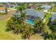 Aerial view of a home featuring a screened pool with vibrant turquoise water and lush foliage at 265 White Marsh Ln, Rotonda West, FL 33947