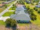 Aerial view of a home with a screened pool, lush landscaping, and a spacious lawn at 265 White Marsh Ln, Rotonda West, FL 33947
