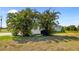 Spacious yard featuring a grill, a white picket fence, and mature palm trees, blending functionality and nature at 265 White Marsh Ln, Rotonda West, FL 33947