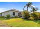 Serene backyard view highlighting a screened-in lanai, lush greenery, and tropical palm trees at 265 White Marsh Ln, Rotonda West, FL 33947
