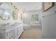 Elegant bathroom featuring double sinks, marble accents, a soaking tub, and natural light at 265 White Marsh Ln, Rotonda West, FL 33947