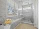 Bright bathroom features a shower with frameless glass doors, white marble walls, and built-in bench seating at 265 White Marsh Ln, Rotonda West, FL 33947