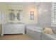 Elegant bathroom with marble accents, soaking tub, double sinks, and well-lit vanity area at 265 White Marsh Ln, Rotonda West, FL 33947