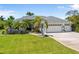 Charming single-story home with a well-manicured lawn, mature palms, and a three-car garage at 265 White Marsh Ln, Rotonda West, FL 33947