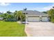 Charming single-story home with a three-car garage, lush landscaping, and a well-manicured lawn at 265 White Marsh Ln, Rotonda West, FL 33947