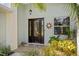 Elegant front door with decorative glass, complemented by manicured landscaping and a decorative sun accent at 265 White Marsh Ln, Rotonda West, FL 33947
