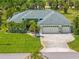 Beautiful home featuring an expansive three-car garage, a manicured lawn, and lush tropical landscaping at 265 White Marsh Ln, Rotonda West, FL 33947