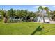 Well-maintained front yard with lush green lawn, mature palms, and a light blue home with a white garage at 265 White Marsh Ln, Rotonda West, FL 33947