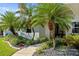 Manicured landscaping featuring mature palms and a concrete walkway to the house at 265 White Marsh Ln, Rotonda West, FL 33947