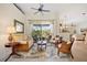 Bright living room with a ceiling fan and access to a screened-in lanai, perfect for relaxation and entertainment at 265 White Marsh Ln, Rotonda West, FL 33947