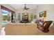 Cozy living room with comfortable seating, a ceiling fan, and a view of the pool area at 265 White Marsh Ln, Rotonda West, FL 33947