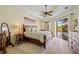 Main bedroom with tray ceiling, ceiling fan, access to pool area, and natural light at 265 White Marsh Ln, Rotonda West, FL 33947