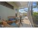 This covered patio with wicker chairs and cocktail table overlooks the pool at 265 White Marsh Ln, Rotonda West, FL 33947
