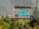 Aerial close-up of a screened pool with clear blue water and paved deck at 265 White Marsh Ln, Rotonda West, FL 33947
