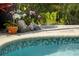 Intricate tile accents the pool's edge, complemented by decorative plant pots and fish sculpture at 265 White Marsh Ln, Rotonda West, FL 33947
