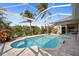 Screened pool with brick pavers, tropical foliage, and clear blue water provides a relaxing outdoor oasis at 265 White Marsh Ln, Rotonda West, FL 33947