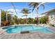 Sparkling screened-in pool with ample patio seating, lush landscaping, and clear blue sky at 265 White Marsh Ln, Rotonda West, FL 33947