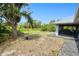 Spacious backyard with a natural, partially wooded perimeter, and view of the screened in porch at 2685 Nanette Ln, North Port, FL 34286