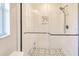 Beautiful walk in shower features a glass door, rain shower head, and white marble-look tile surround at 2685 Nanette Ln, North Port, FL 34286