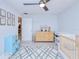 Well-lit bedroom with neutral walls, playful decor, and an adjacent changing table and crib at 2685 Nanette Ln, North Port, FL 34286