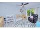 Charming bedroom with light walls, a crib, and a cozy reading corner with a leather chair at 2685 Nanette Ln, North Port, FL 34286