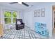 Cozy bedroom with a ceiling fan, comfortable recliner, soft rug, and natural light from a large window at 2685 Nanette Ln, North Port, FL 34286