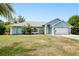 Charming, one story, light blue home with a well-manicured front lawn and a white two car garage door at 2685 Nanette Ln, North Port, FL 34286