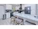 Beautiful kitchen features white cabinets, gray backsplash and a large granite island with seating at 2685 Nanette Ln, North Port, FL 34286