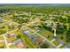 Expansive aerial view of neighborhood with lush greenery and manicured lawns surrounding well-maintained homes at 27263 Deep Creek Blvd, Punta Gorda, FL 33983