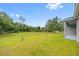 Spacious backyard with lush green lawn and trees, perfect for outdoor activities at 27263 Deep Creek Blvd, Punta Gorda, FL 33983