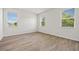 Bright and airy bedroom featuring three windows and light-colored, wood-look laminate flooring at 27263 Deep Creek Blvd, Punta Gorda, FL 33983