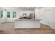 Modern kitchen with white cabinets, stainless steel appliances, large island, and hardwood floors at 27263 Deep Creek Blvd, Punta Gorda, FL 33983