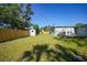 Grassy backyard with a shed, wooden fence, and mature trees at 31 Oberlin Rd, Venice, FL 34293