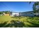 Expansive backyard features a wooden deck, lawn, and sunny skies at 31 Oberlin Rd, Venice, FL 34293